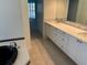 Bathroom featuring a large black tub, double sinks, and modern white cabinets with tile flooring at 1093 Laurel Woods Dr, Nokomis, FL 34275