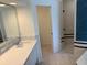 Bathroom featuring a white countertop, modern mirror, and tile flooring, alongside an open shower at 1093 Laurel Woods Dr, Nokomis, FL 34275