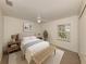 Neutral bedroom with decorative bench seating, ceiling fan, and natural lighting at 1093 Laurel Woods Dr, Nokomis, FL 34275