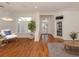 Bright living room with hardwood floors, white walls, and a large window with plantation shutters at 1093 Laurel Woods Dr, Nokomis, FL 34275