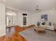 Bright living room features hardwood floors, modern ceiling fan, and decorative front doors at 1093 Laurel Woods Dr, Nokomis, FL 34275