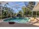 Screened-in pool area with lush landscaping, creating a private and tropical oasis at 1093 Laurel Woods Dr, Nokomis, FL 34275