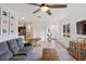Spacious living room features a ceiling fan and natural light with view to the kitchen and entry door at 11915 Tempest Harbor Loop, Venice, FL 34292