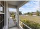 Screened porch showcases a serene street view with lush landscaping under a bright blue sky at 11915 Tempest Harbor Loop, Venice, FL 34292
