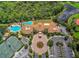 Overhead aerial view of community center with pools, tennis courts, and parking with lush natural backdrop at 133 Treviso Ct, North Venice, FL 34275