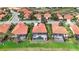 Aerial view of houses with red tile roofs, screened-in pools, and manicured lawns in a lakeside community at 133 Treviso Ct, North Venice, FL 34275