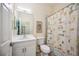 Bright bathroom features white vanity, a toilet, a framed mirror, and a shower with a fun shower curtain at 133 Treviso Ct, North Venice, FL 34275