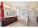 Bright bathroom features double sinks, soaking tub, glass block window, and walk-in shower at 133 Treviso Ct, North Venice, FL 34275