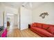 Red sofa in a bedroom with wood floor, with door leading to living room at 133 Treviso Ct, North Venice, FL 34275