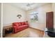 Cozy bedroom featuring a red sofa, wood flooring, and a bright window at 133 Treviso Ct, North Venice, FL 34275