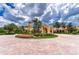 Elegant clubhouse entrance featuring manicured landscaping and classic Mediterranean architecture with prominent tower feature at 133 Treviso Ct, North Venice, FL 34275