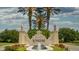 Grand Venetian Golf & River Club entrance with lush landscaping, stately lion statues, and a charming water fountain at 133 Treviso Ct, North Venice, FL 34275