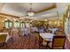 Elegant dining room with beautifully set tables, tasteful decor, and large windows providing abundant natural light at 133 Treviso Ct, North Venice, FL 34275