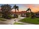 Charming single-story home featuring a red tile roof, lush landscaping, and a welcoming driveway at 133 Treviso Ct, North Venice, FL 34275