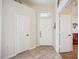 Bright foyer showcasing tile flooring, white doors, transom window, and open access to other rooms at 133 Treviso Ct, North Venice, FL 34275
