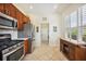 Modern kitchen with stainless steel appliances, cherry cabinets, tiled backsplash, and ample natural light at 133 Treviso Ct, North Venice, FL 34275