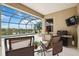 Spacious covered lanai with ample seating, a barbecue, and stunning lake and pool views at 133 Treviso Ct, North Venice, FL 34275