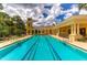 Inviting lap pool with clearly marked lanes, surrounded by a deck with railings, and clubhouse in the background at 133 Treviso Ct, North Venice, FL 34275