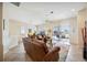 Bright living area showcasing leather seating, a ceiling fan, and access to the outdoor patio at 133 Treviso Ct, North Venice, FL 34275