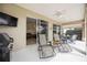 Relaxing covered patio with outdoor seating and a view of the home's interior at 133 Treviso Ct, North Venice, FL 34275
