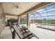 Covered patio area offering serene lake views and featuring a jacuzzi, lounge chairs and ceiling fan at 133 Treviso Ct, North Venice, FL 34275