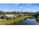 Scenic aerial view of homes with palm trees lining a tranquil canal under a beautiful sky, offering serene waterfront living at 174 Southampton S Pl # 345, Venice, FL 34293