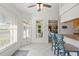 Bright breakfast nook with white tile floors and charming blue chairs, adjacent to the kitchen and living area at 174 Southampton S Pl # 345, Venice, FL 34293