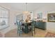 Inviting dining area featuring a chandelier, stylish blue chairs, and a coordinating blue accent cabinet at 174 Southampton S Pl # 345, Venice, FL 34293