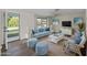 Cozy living room with a blue sofa, rattan chairs, and beach-themed decor, perfect for relaxation at 18053 Cullman Ave, Port Charlotte, FL 33948