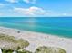 Breathtaking aerial view of a serene beach with crystal-clear turquoise water and pristine white sand at 19832 Bridgetown Loop, Venice, FL 34293