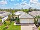 Aerial view of a light yellow single-Gathering home with a well manicured front yard and a brick driveway at 19832 Bridgetown Loop, Venice, FL 34293