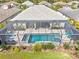 Aerial view of a backyard with a caged pool, spa, and lounge area at 19832 Bridgetown Loop, Venice, FL 34293