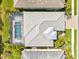 An aerial top down shot of a home with a screened in pool, palm trees and green grass at 19832 Bridgetown Loop, Venice, FL 34293