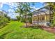 A serene backyard features a screened-in pool and well-maintained lawn at 19832 Bridgetown Loop, Venice, FL 34293