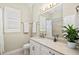 Bright bathroom featuring a vanity with marble countertop, a sink, window and a walk-in shower at 19832 Bridgetown Loop, Venice, FL 34293