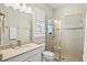 Bathroom showcasing a vanity with a granite countertop, a window and a glass shower stall at 19832 Bridgetown Loop, Venice, FL 34293