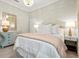 Charming bedroom featuring a stylish bed, elegant lamps, and a decorative mirror that complements the room's serene ambiance at 19832 Bridgetown Loop, Venice, FL 34293