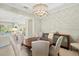 Elegant dining room featuring a modern chandelier, wood table and views to the living area at 19832 Bridgetown Loop, Venice, FL 34293