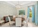 Dining room with a round wood table, decorative chandelier, and stylish curtains at 19832 Bridgetown Loop, Venice, FL 34293