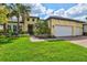 Charming yellow house with a well-manicured lawn and lush landscaping at 19832 Bridgetown Loop, Venice, FL 34293