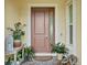 Warm, welcoming front door with a side window and decorative plants at 19832 Bridgetown Loop, Venice, FL 34293