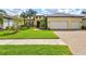 Charming single-story home with a two-car garage, lush lawn, and manicured landscaping at 19832 Bridgetown Loop, Venice, FL 34293