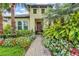 Inviting front entrance with a brick walkway and colorful flower beds at 19832 Bridgetown Loop, Venice, FL 34293