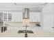 Well-lit kitchen with white cabinetry, stainless steel appliances, and decorative backsplash at 19832 Bridgetown Loop, Venice, FL 34293