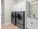 Laundry room with front-loading washer and dryer, overhead cabinets, and a utility sink at 19832 Bridgetown Loop, Venice, FL 34293