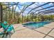 A gorgeous screened-in pool and spa surrounded by greenery and lush landscaping at 19832 Bridgetown Loop, Venice, FL 34293