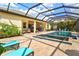 A beautiful caged pool features a built-in spa and sun loungers for relaxation at 19832 Bridgetown Loop, Venice, FL 34293