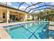 A sparkling blue pool features a waterfall and seating, perfect for enjoying sunny days at 19832 Bridgetown Loop, Venice, FL 34293