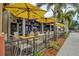 Outdoor restaurant seating area with yellow umbrellas providing shade over tables and chairs at 19832 Bridgetown Loop, Venice, FL 34293