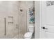 Bright bathroom showcasing a glass-enclosed shower with tiled walls, a toilet, and modern fixtures at 19836 Bridgetown Loop, Venice, FL 34293